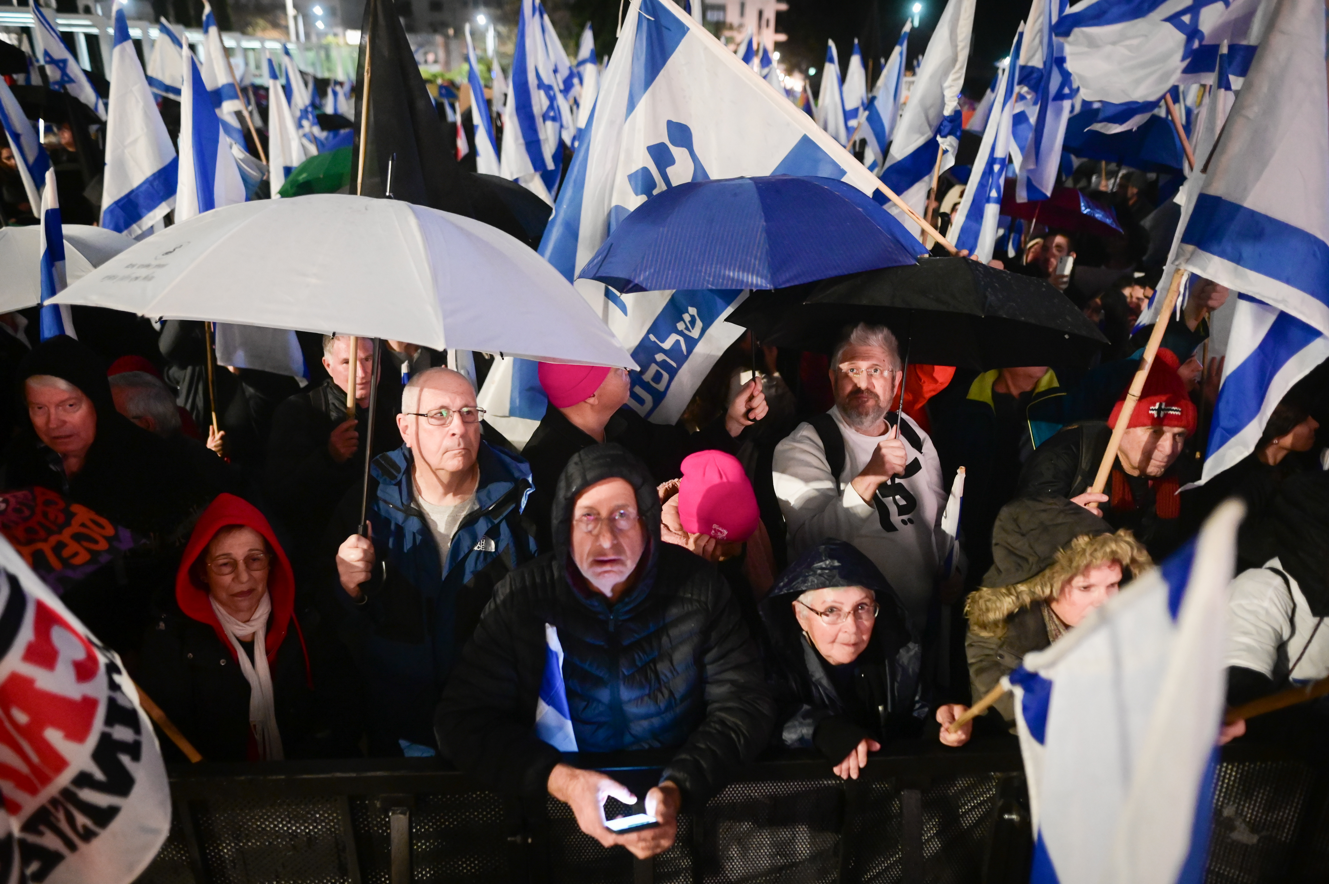 Umbrellas up at massive TLV protest; West Bank warnings